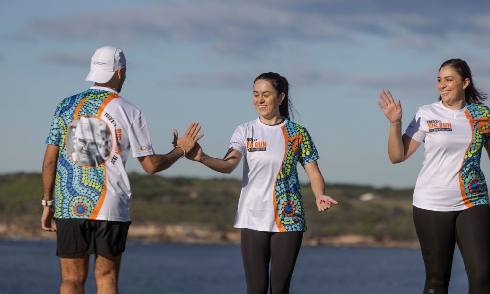 Three people high fiving during their run at The Foundation's fundraiser, Fred's Big Run