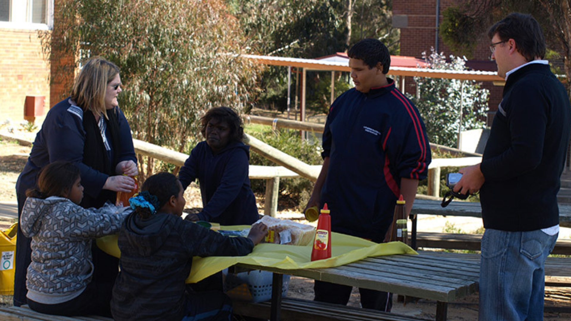 Fundraisers setting up a park bench with food