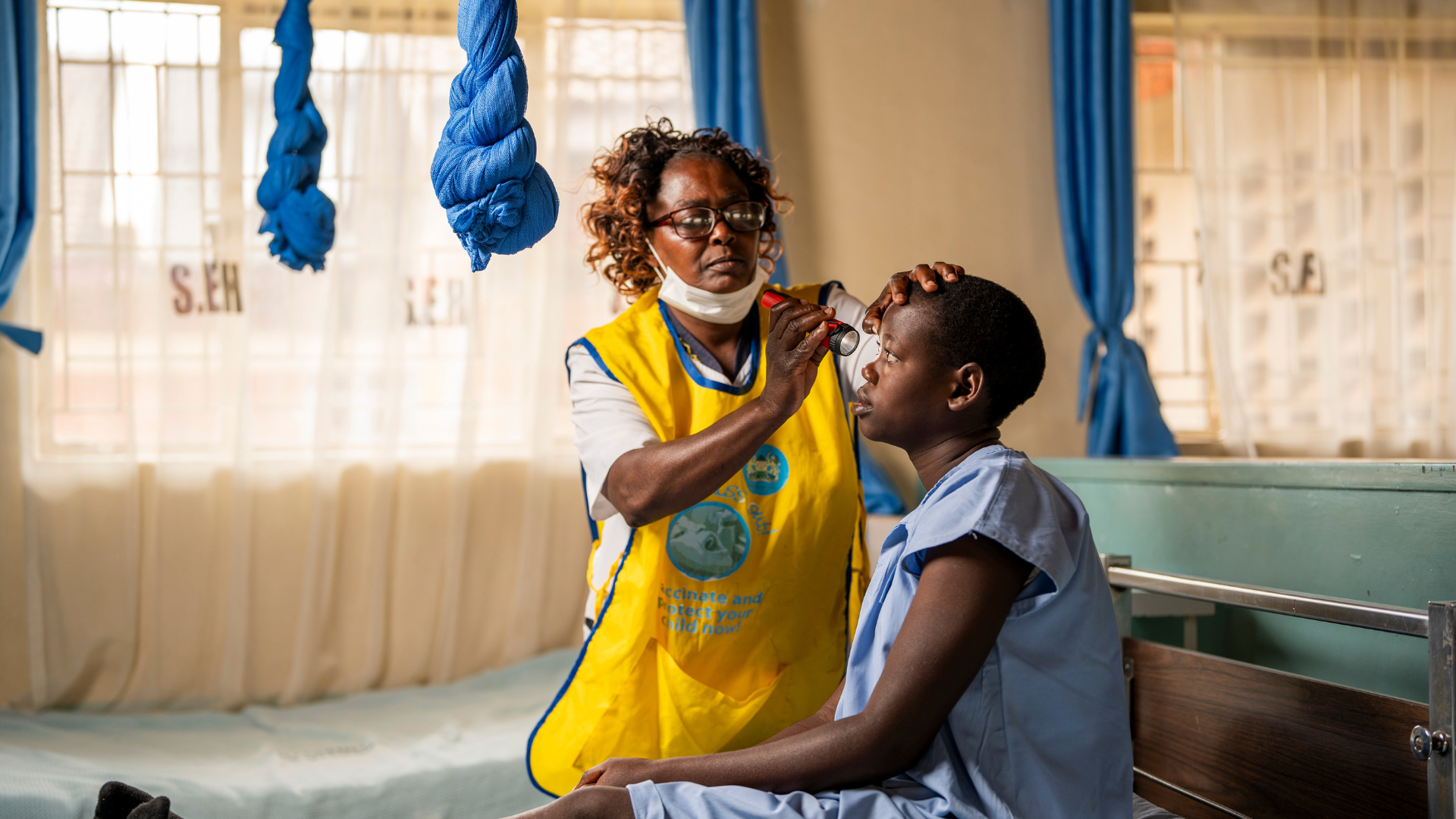 Mitchel getting her eyes examined by a community health worker