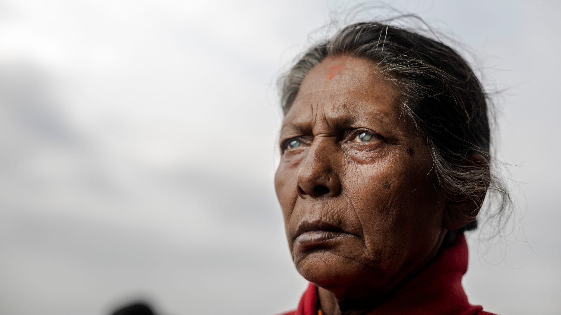 A close up of a woman from Nepal with cataracts looking out into the distance