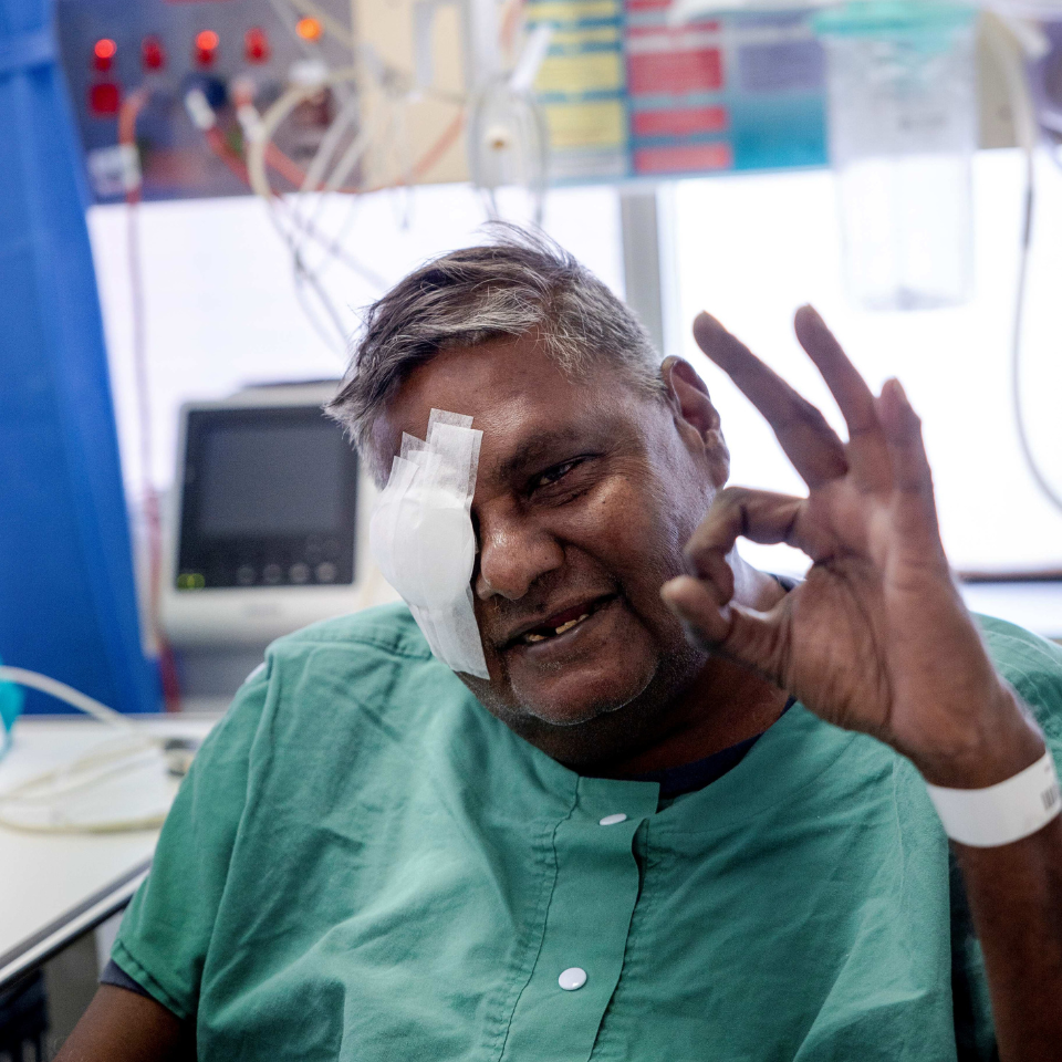 Don with his eye patch off, smiling at the camera, giving the 'ok' hand gesture to the camera.