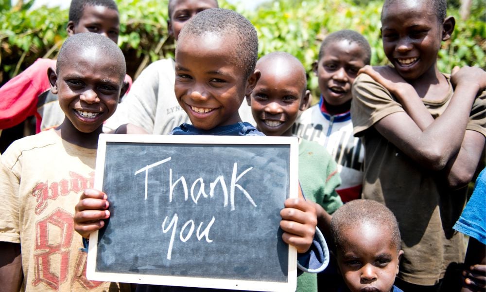 Kenyan boy holding a 'thank you' sign