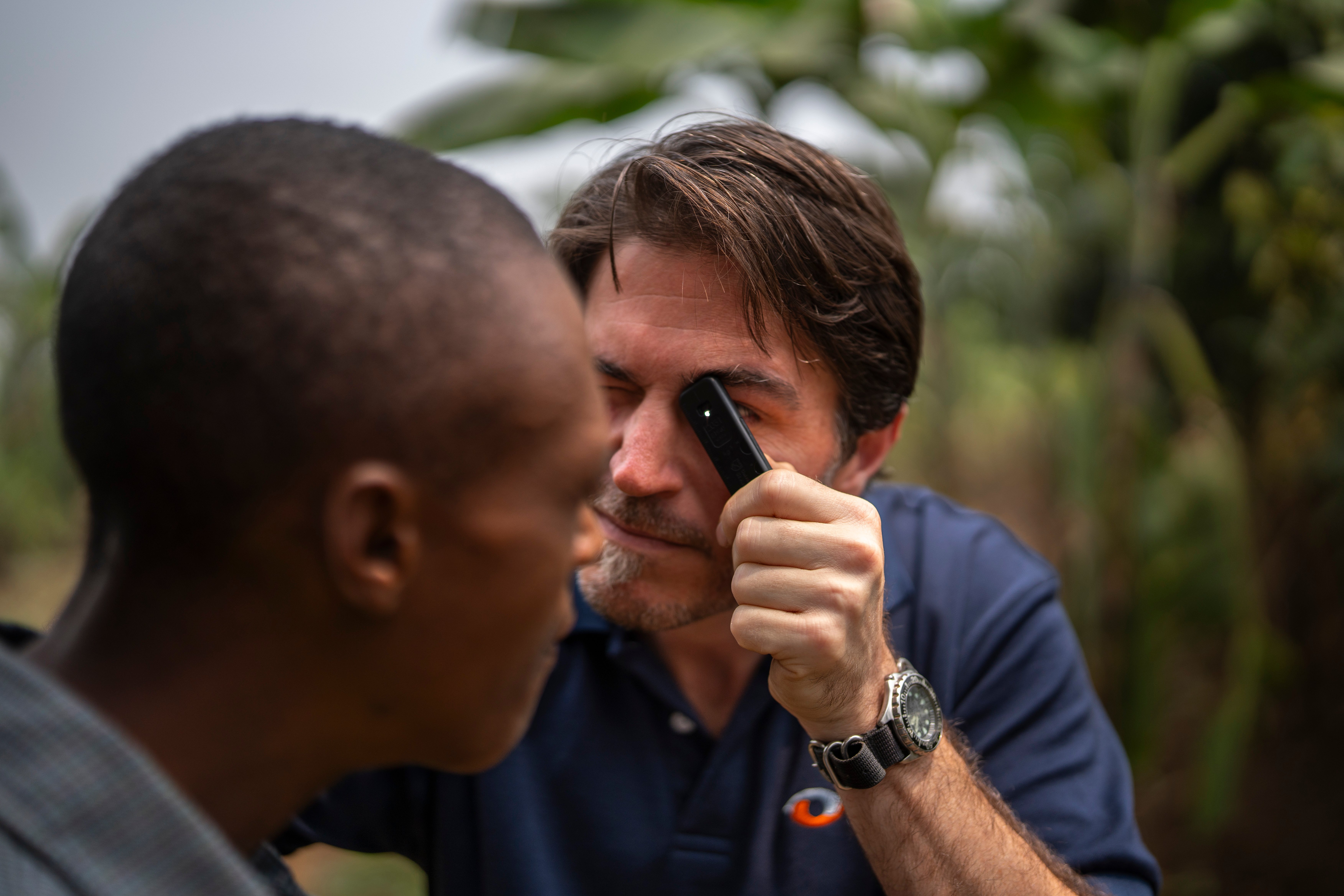 Cam Hollows examining a patients eyes in Rwanda, 2024.