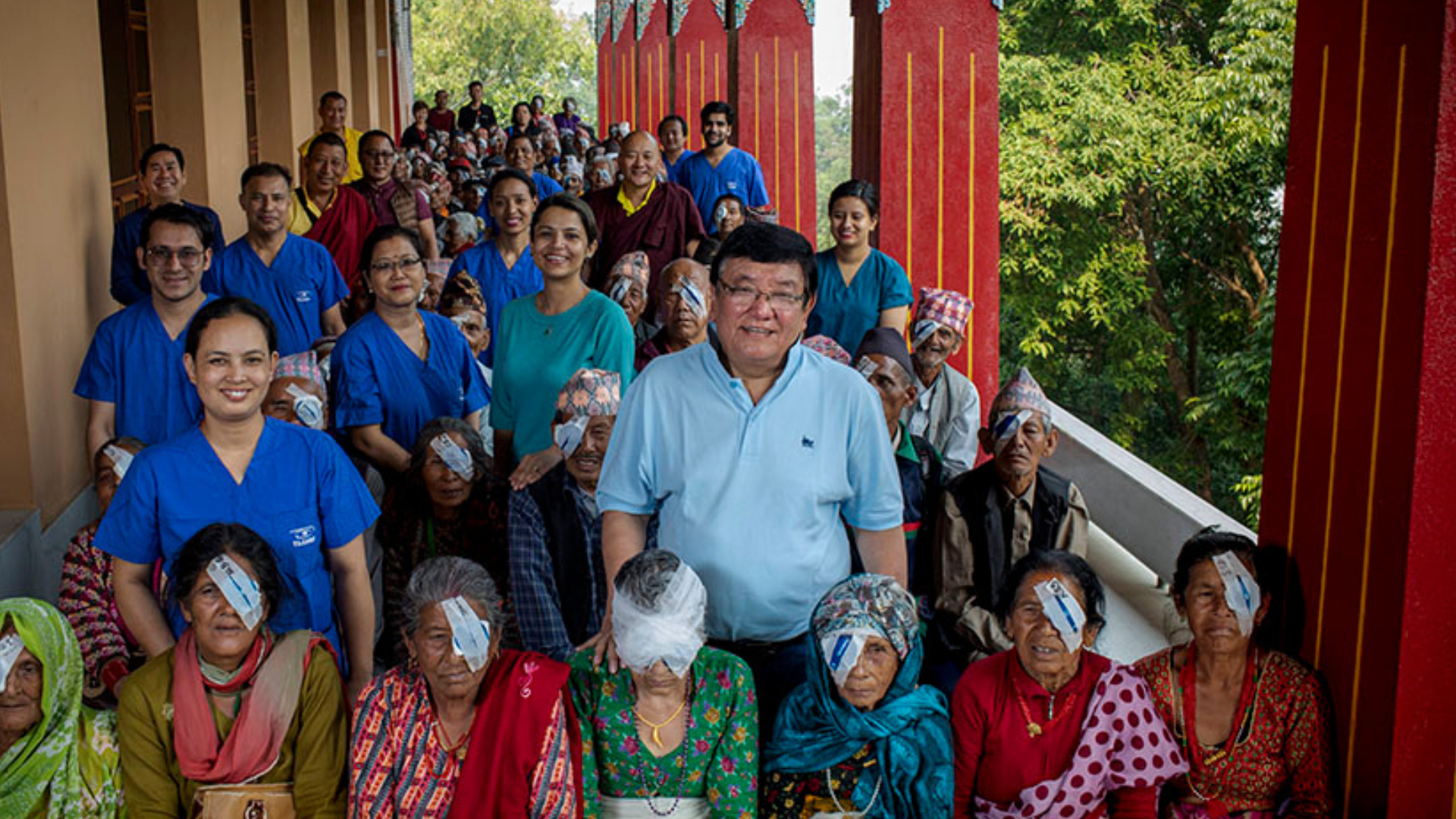 Dr Ruit surrounded by his patients wearing eye patches