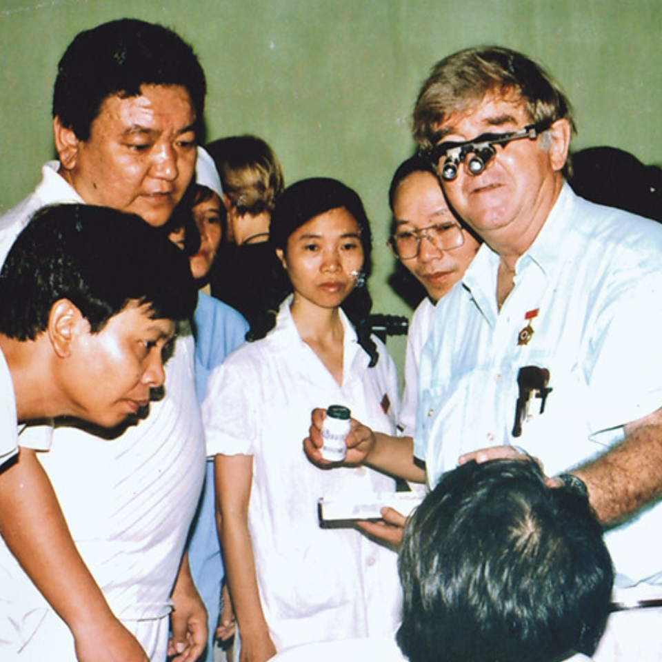 Fred Hollows standing with Dr Ruit looking at a patient