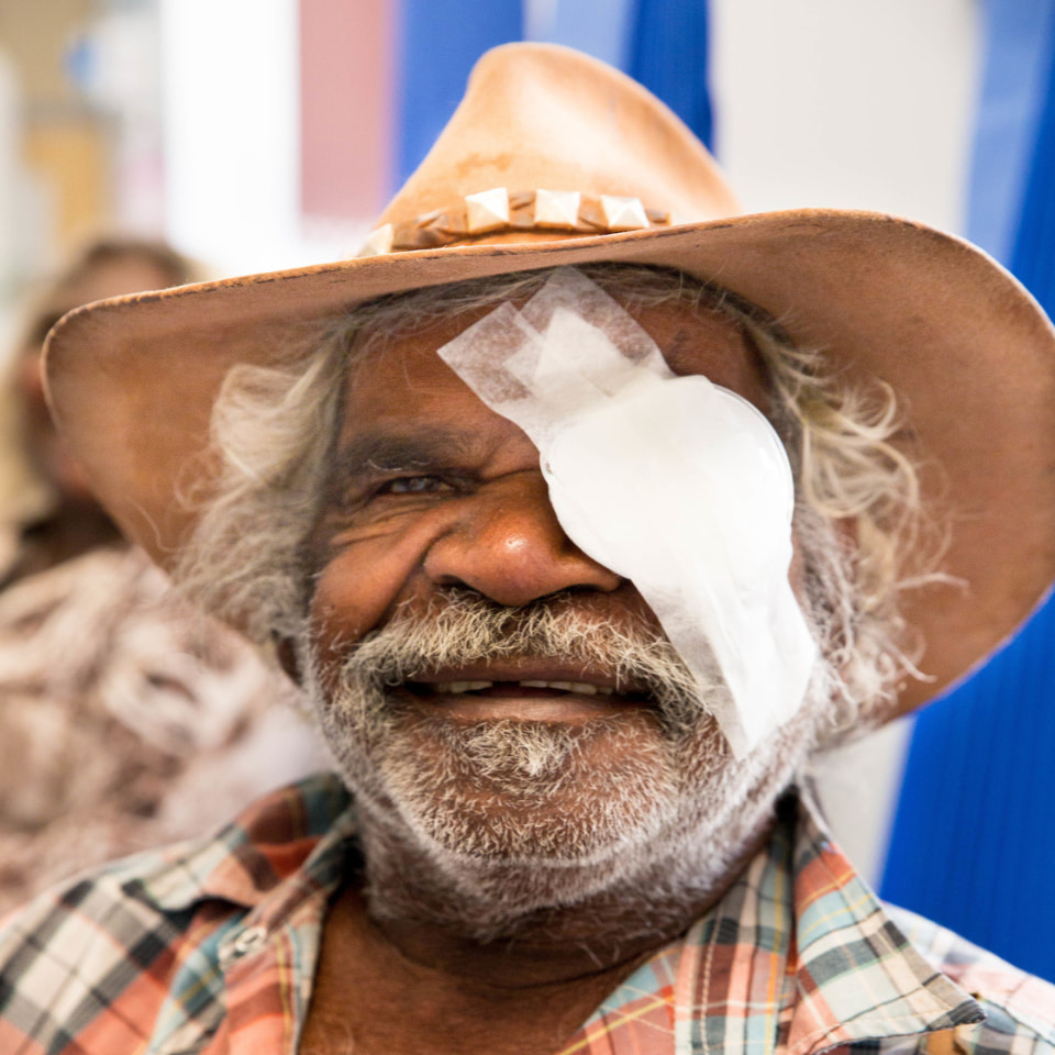 Indigenous man with a patch over his eye posing after eye surgery 