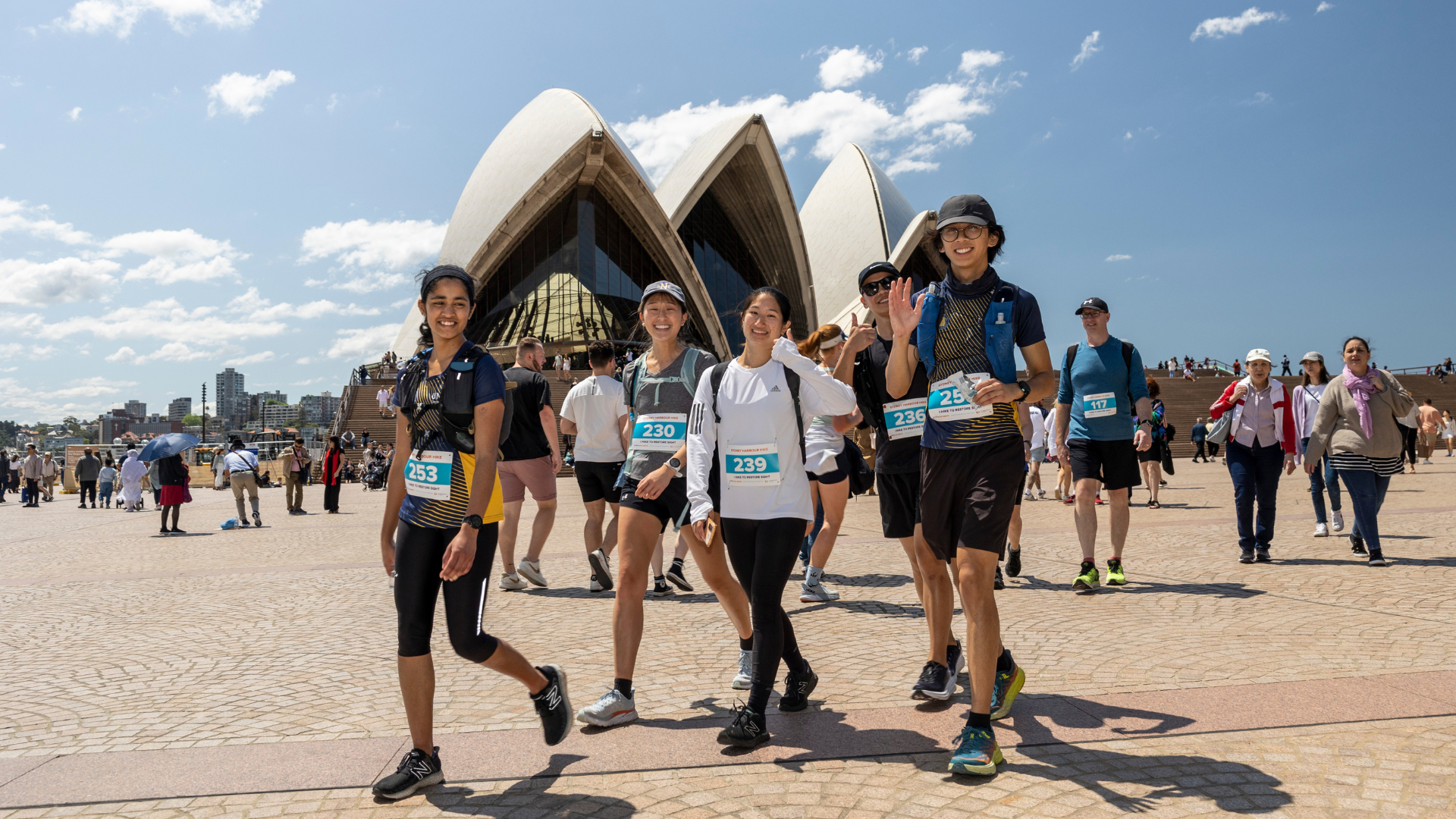 A group of fundraisers walking past the Sydney Opera House for the Sydney Habour Hike 