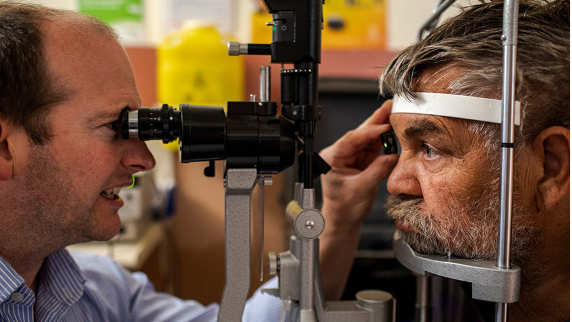 A man examining another mans eyes 