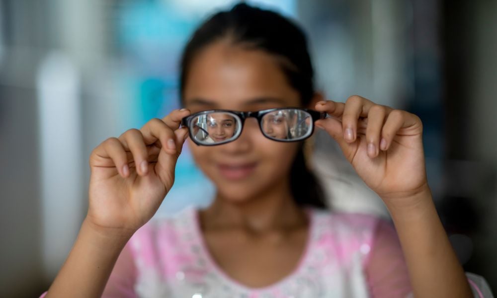 Gril from Bangladesh holding glasses up to the camera