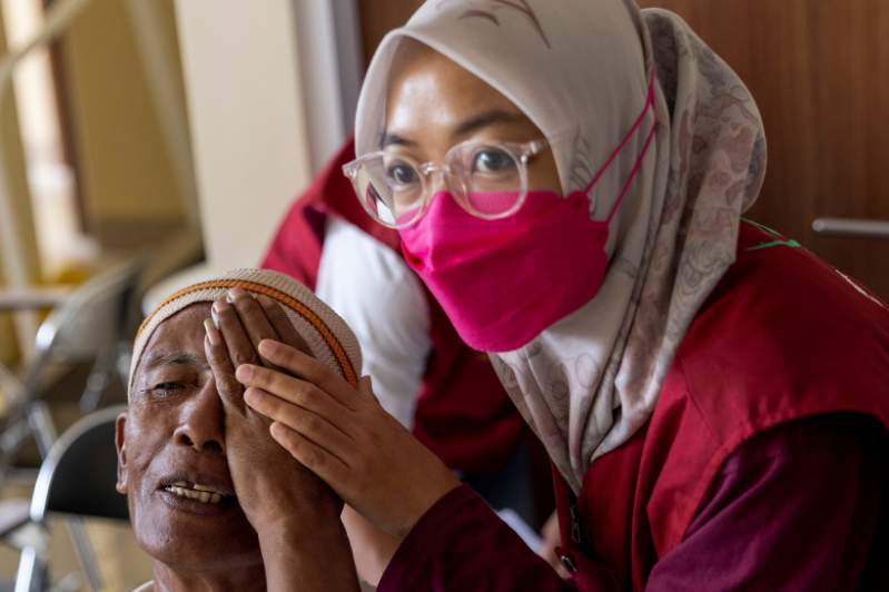 Nurse tests mans eyes in Nepal 