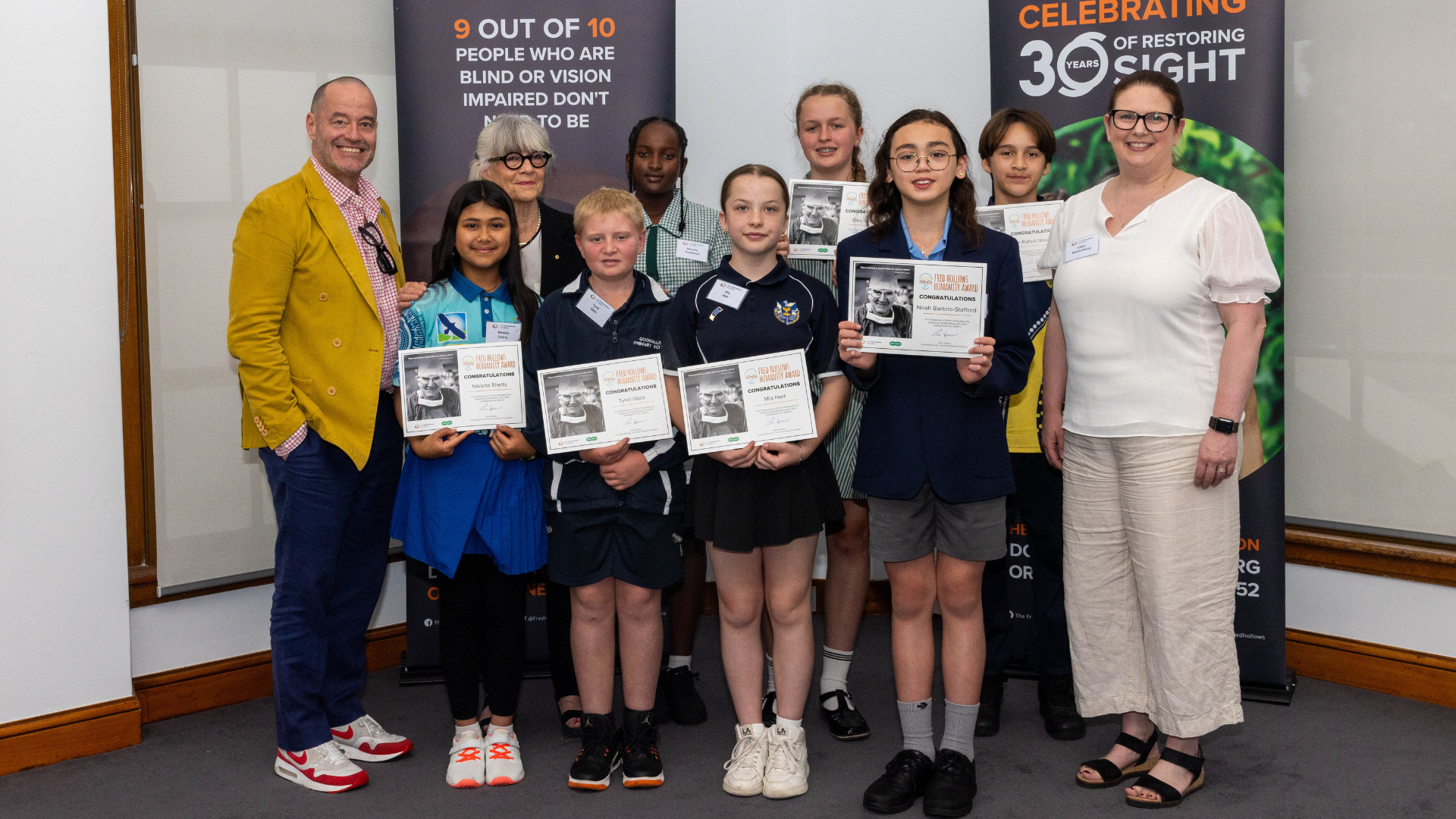 Gabi Hollows and host of the Fred Awards, Adam Spencer, posing with the humanity awards winners