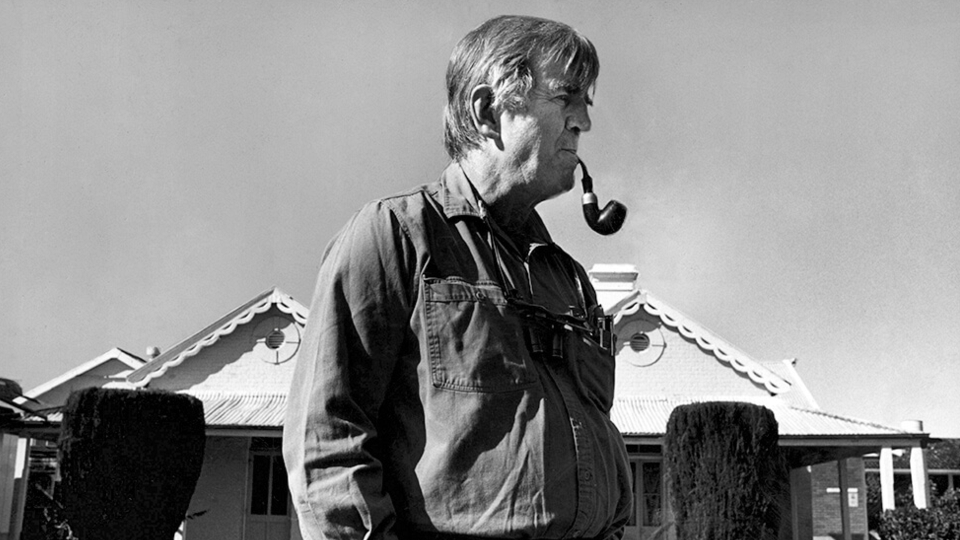 Fred Hollows standing outside Bourke Hospital with his signature pipe in his mouth