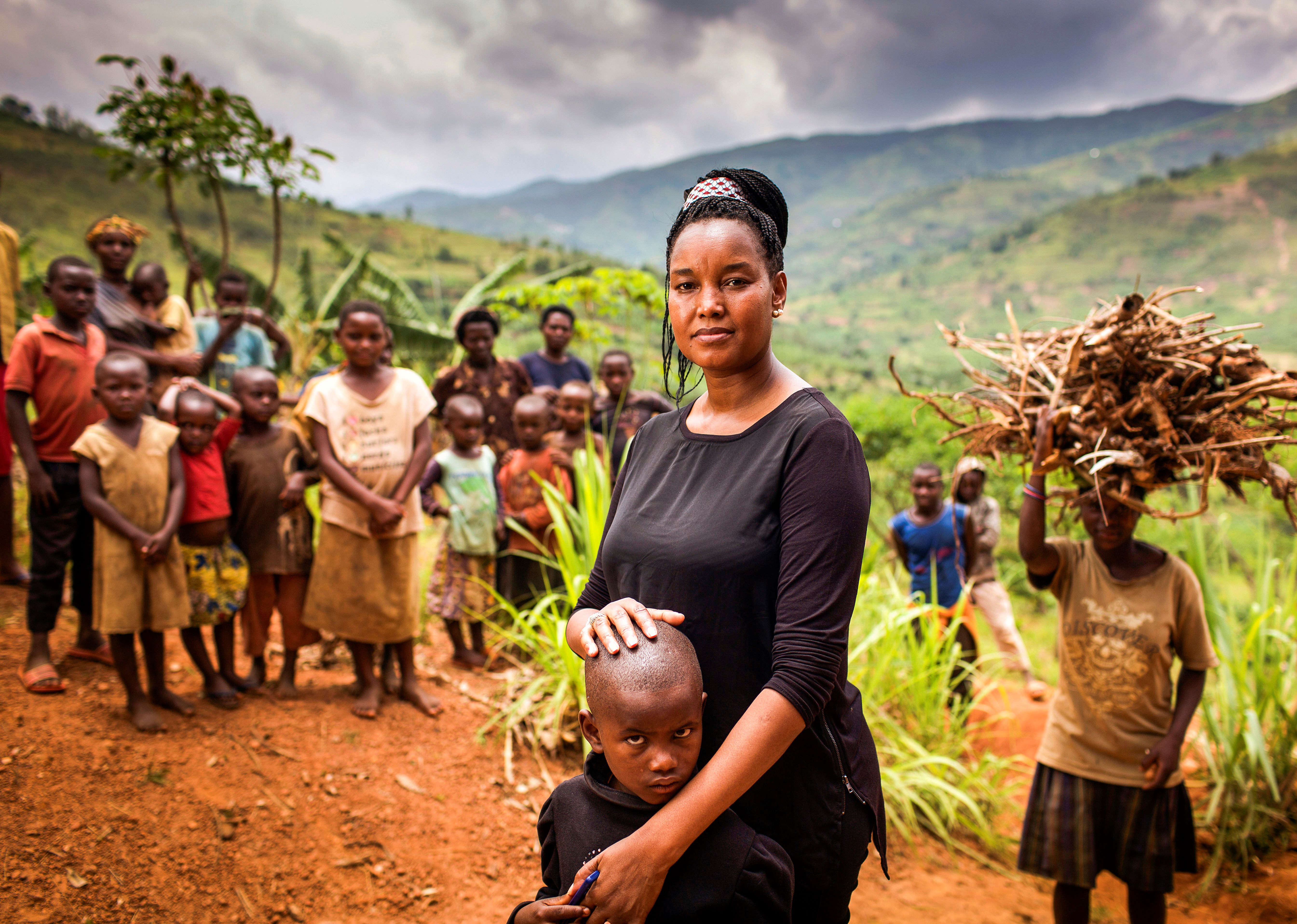 A portrait of Dr. Ciku, the first female ophthalmologist in Africa trained by The Fred Hollows Foundation, and patient Eric. Eric's family and friends are in the background. Picture taken by Michael Amendolia in Rwanda, 2016. 