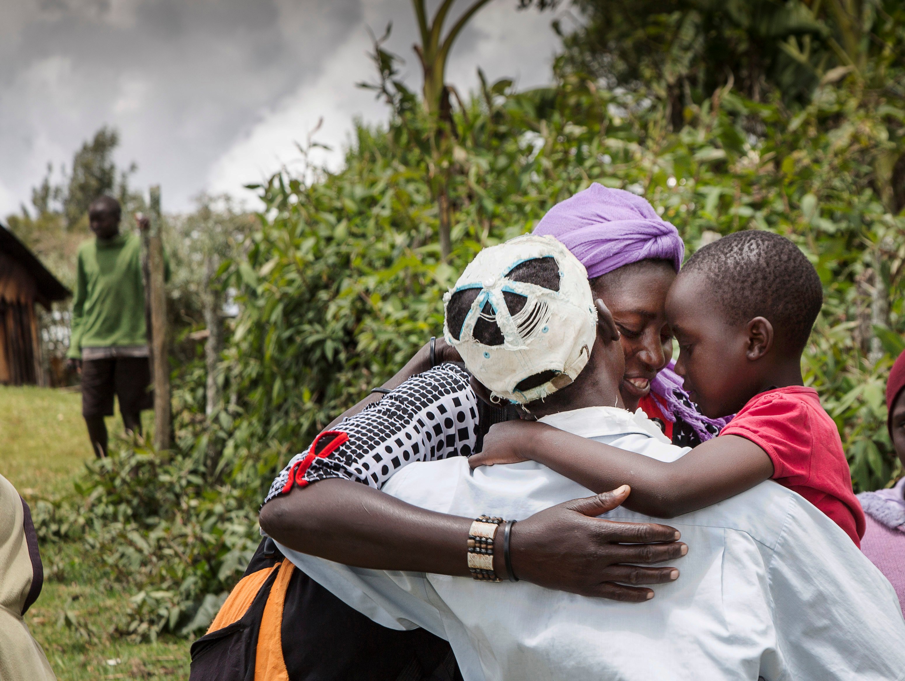 Seven-year-old Nabiritha rushes into the warm embrace of her father, Ramadhan, alongside her mother, Emily, as he returns home a day after restoring her sight. Picture taken by Michael Amendolia in 2016.