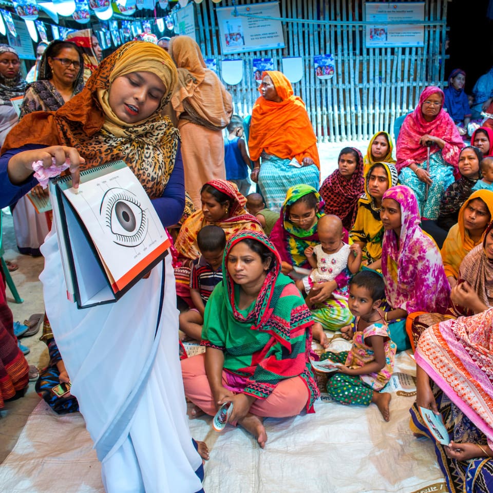 Health care worker teaching community members about eye health