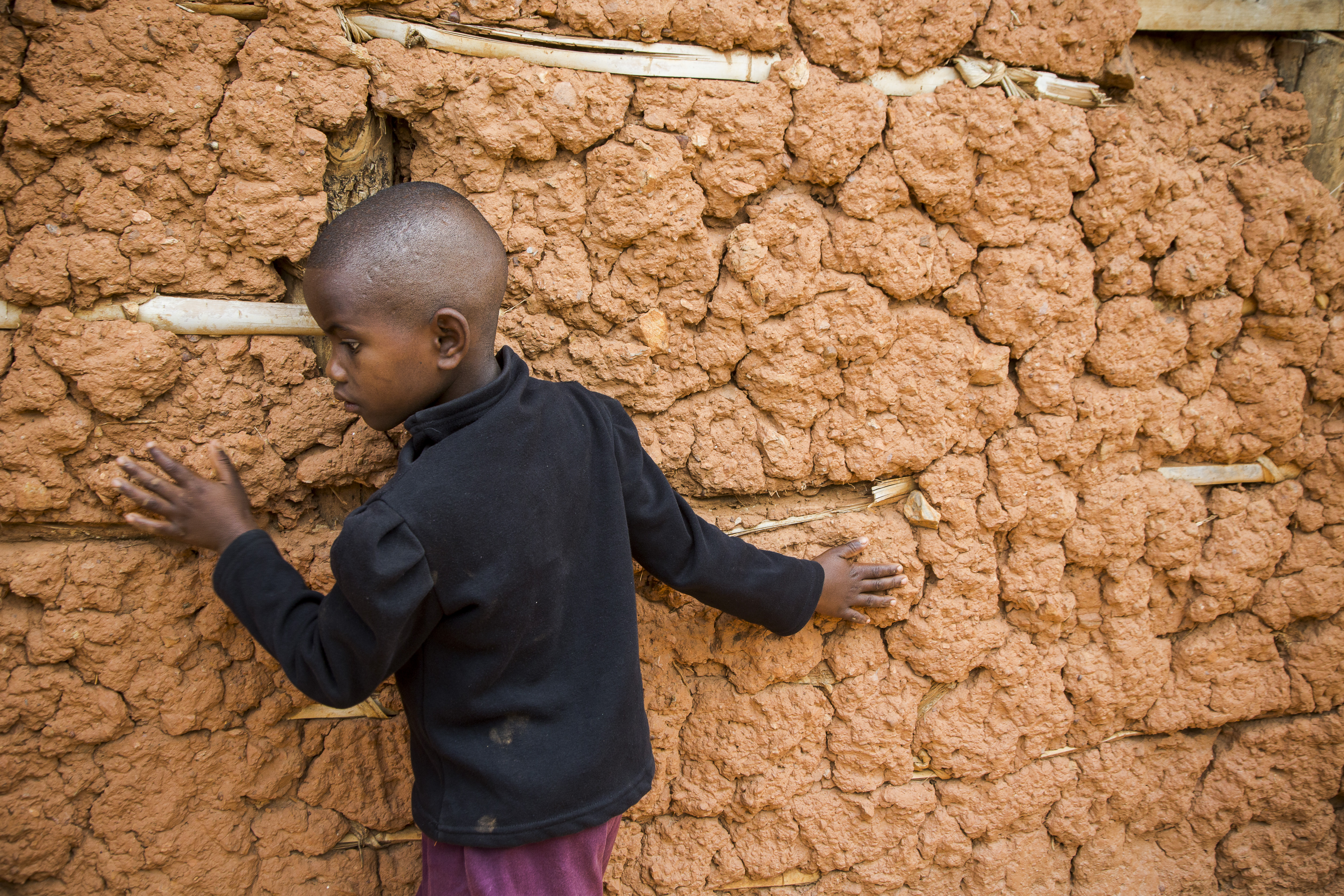 Eric from Rwanda leaning against a wall